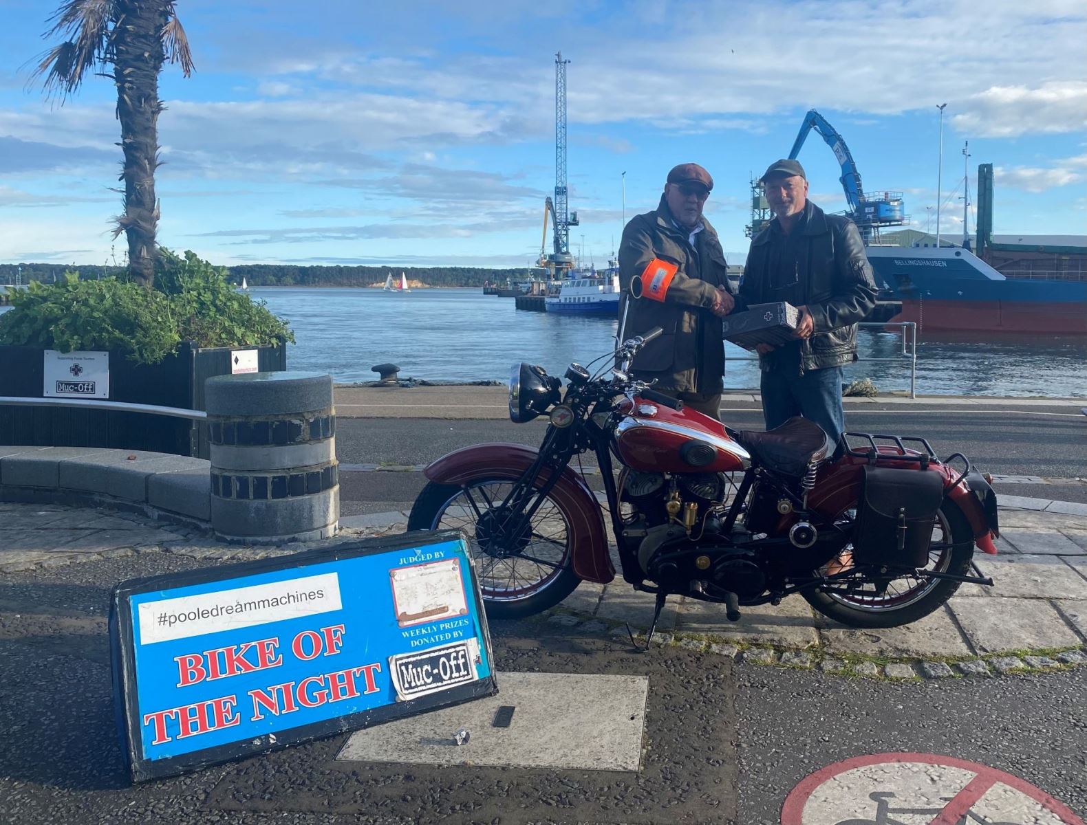 Two men standing next to bike at Poole quay